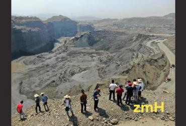   Observers look at the worksite that was flooded with mud after the dam breach on the outskirts of Kachin state's Hpakant township. (Zaw Moe Htet)