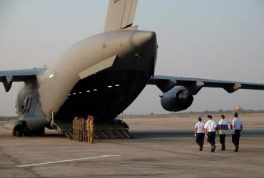 US military honor guards carry the flag draped coffin bearing the recovered remains of suspected American airmen during a repatriation ceremony at the Mandalay International Airport on March 12, 2019. (Ye Aung Thu / AFP)