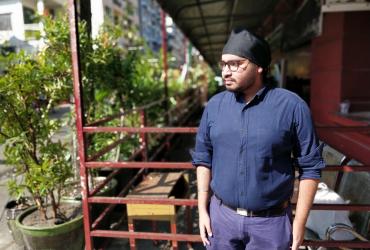 Climate and rights activist Zay Linn Mon stands outside the former Punjab school in Yangon where his brother was told to remove his turban. (Photos by Lorcan Lovett)