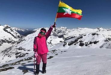 Saint Htet holds the Myanmar flag on Mount Phangran Razi. (The Summiter Group / Facebook)