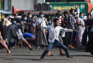 Supporters of Myanmar's military throw objects at residents in Yangon on Thursday (Sai Aung Main / AFP)