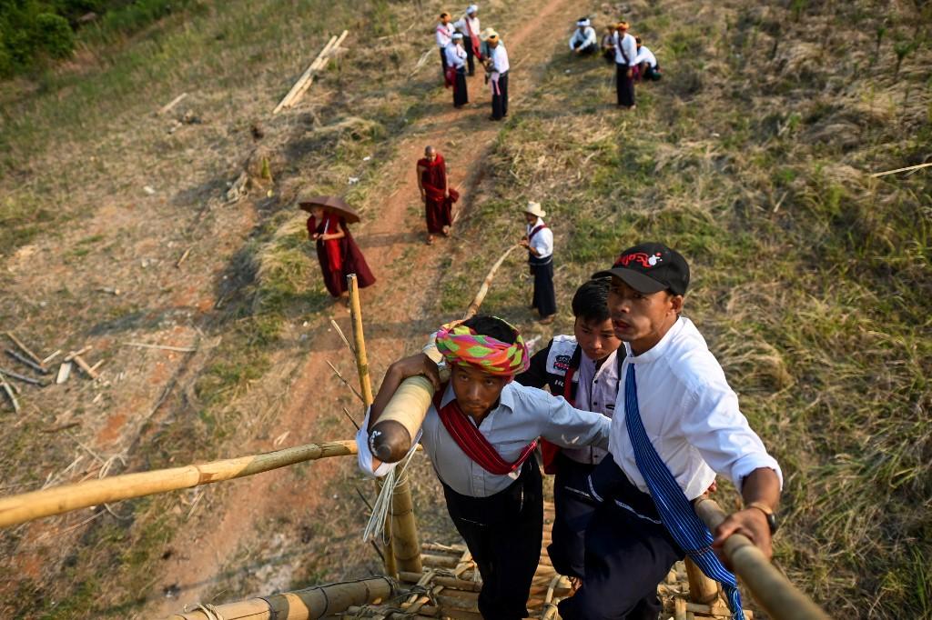 A Pa'O ethnic man carries a homemade rocket to launch during a festival in Nantar, Shan state. (Ye Aung Thu / AFP)