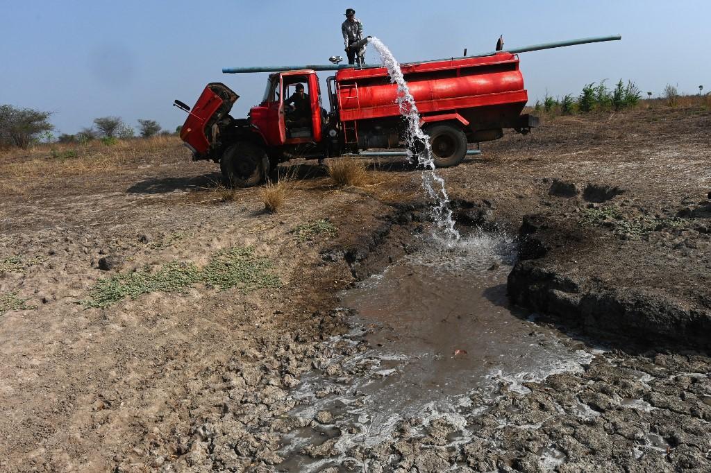 Forest rangers pump water to fill a lake in the Shwe Settaw nature reserve in Magway region. (Ye Aung Thu / AFP)