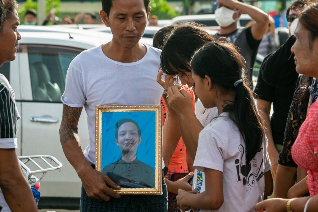 A relative holds a photograph of Kyaw Zin Win. (Sai Aung Main / AFP)