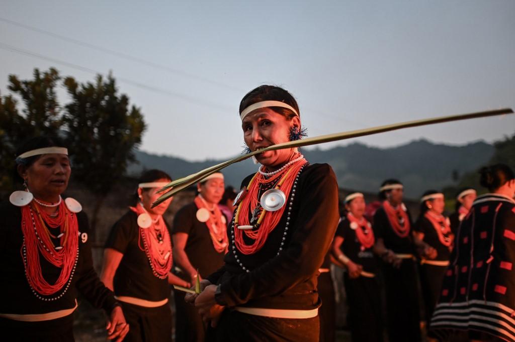 A Naga tribeswoman bites a coconut leaf at the end of an overnight ceremony to bless the harvest in Satpalaw Shaung village. (Ye Aung Thu / AFP)