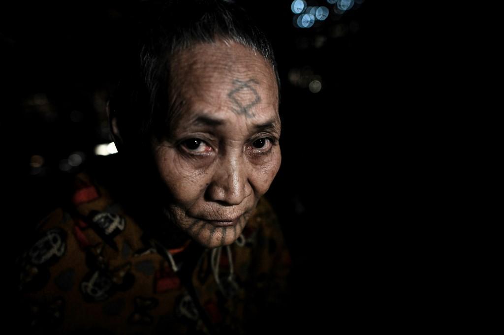 This photo taken on February 6, 2020 shows Khamyo Pon Nyun, 75, a tattooed Lainong tribeswoman resting at her house at Lahel township in Sagaing region. 