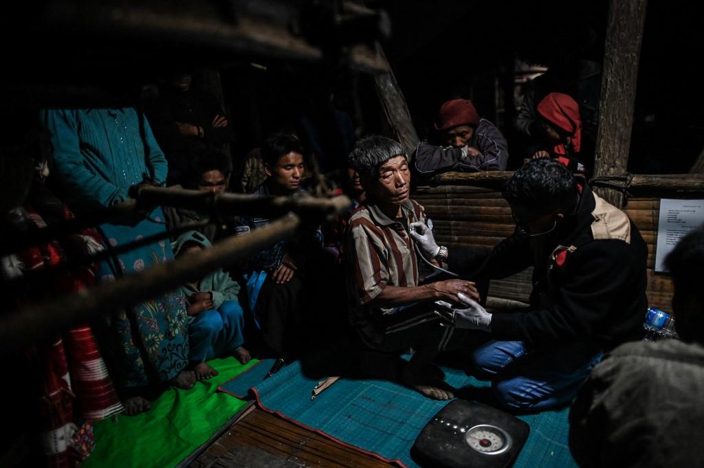 Medical Action Myanmar (MAM) doctor Zaw Min Lay (R) treats a member of a Naga tribe at a mobile clinic in Khar Lay village in Lahel township. (Ye Aung Thu / AFP)