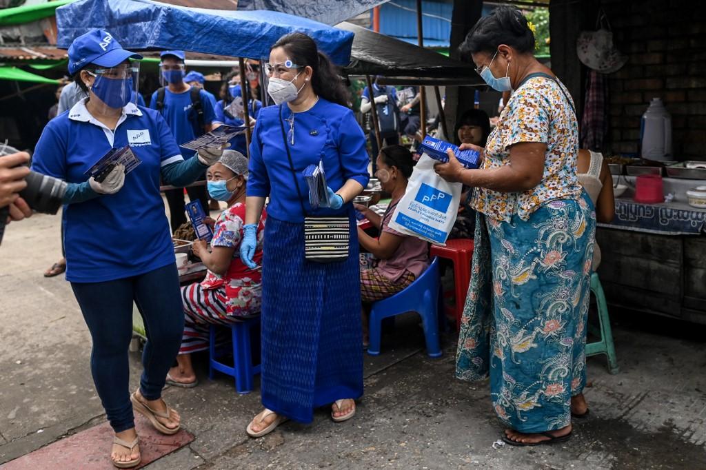 Thet Thet Khine (C), chairman of the People's Pioneer Party (PPP), giving out campaign literature to vendors during the launch of the party's campaign ahead of the upcoming general election in Yangon. (Ye Aung Thu / AFP)