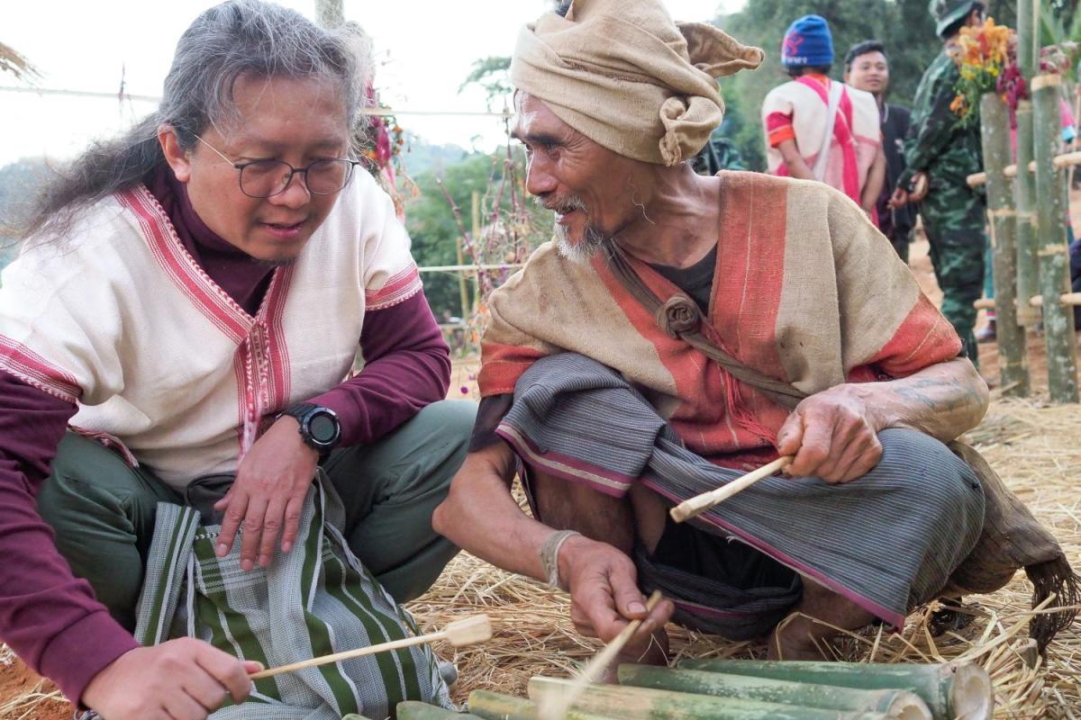 Paul Sein Twa (left) tries a traditional musical instrument during Karen New Year in the animist village Tha Thwee Der located in the Salween Peace Park. (Brennan O’Connor/The Goldman Environmental Prize)