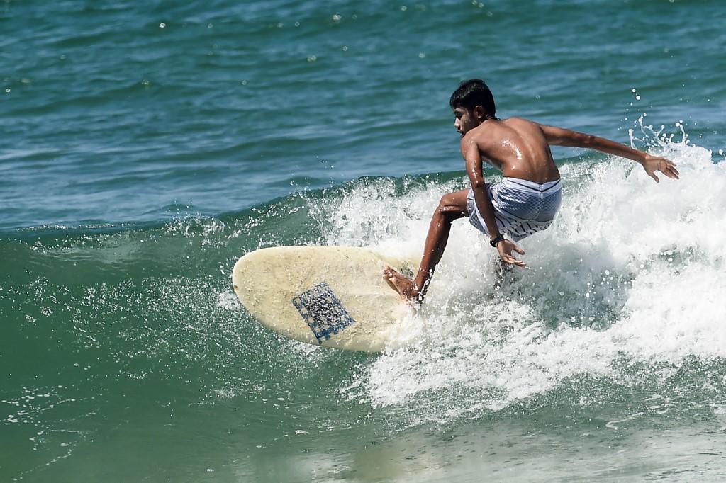  This picture taken on October 12, 2019 shows a surfer riding a wave on Ngwe Saung beach in Irrawaddy division. (Ye Aung Thu / AFP)