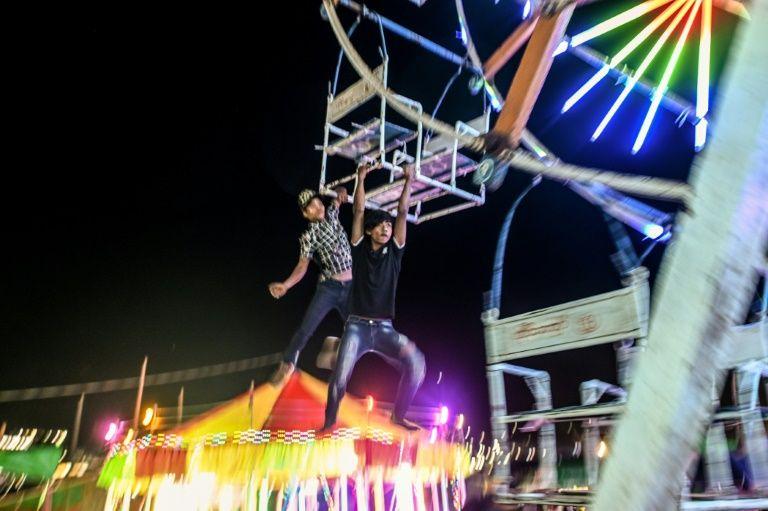 The team of youngsters coax onlookers onto their Ferris ride, hamster-wheeling it round to fill up the baskets (AFP Photo/Ye Aung Thu)