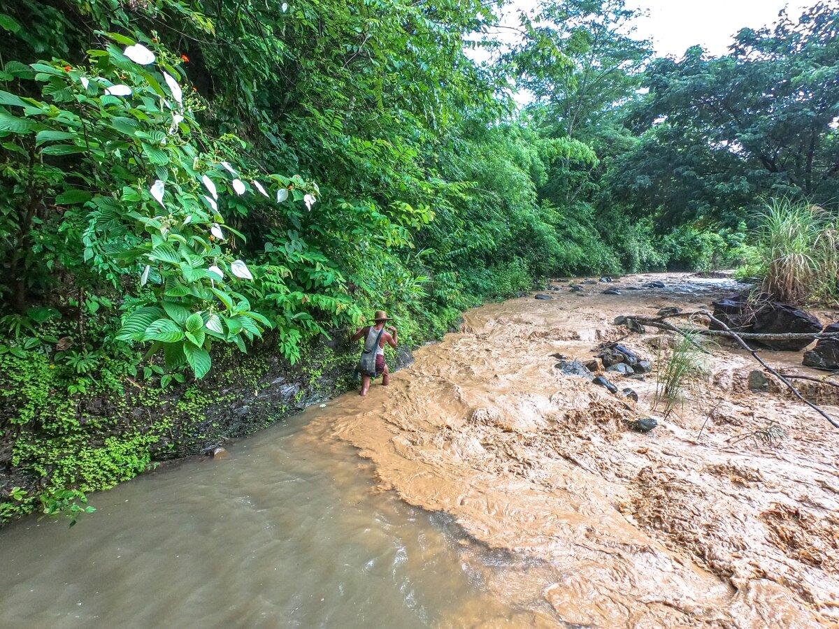 Our guide, a local farmer, crosses one of several rivers on route to the waterfall. (Dominic Horner)