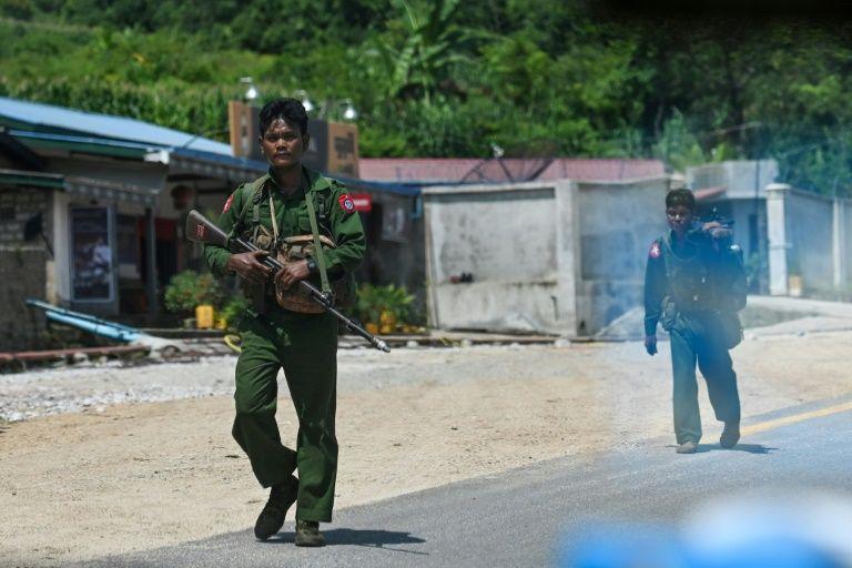  Myanmar soldiers walk along the Pyidaungsu highway road outside Kutkai in Shan State. (Ye Aung Thu / AFP)