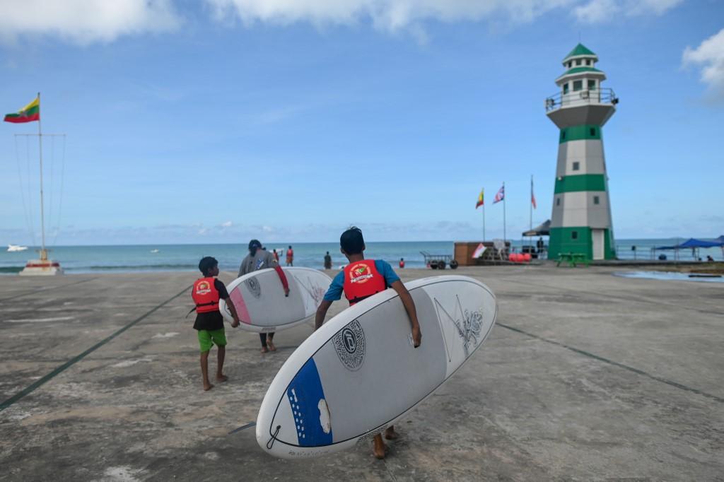 This picture taken on October 13, 2019 shows amateur surfers preparing to take part in a surfing practice session on Ngwe Saung beach in Irrawaddy division. (Ye Aung Thu / AFP)