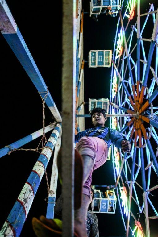 A crew member operates a human-powered ferris wheel in Taunggyi, Shan state. (Ye Aung Thu / AFP)