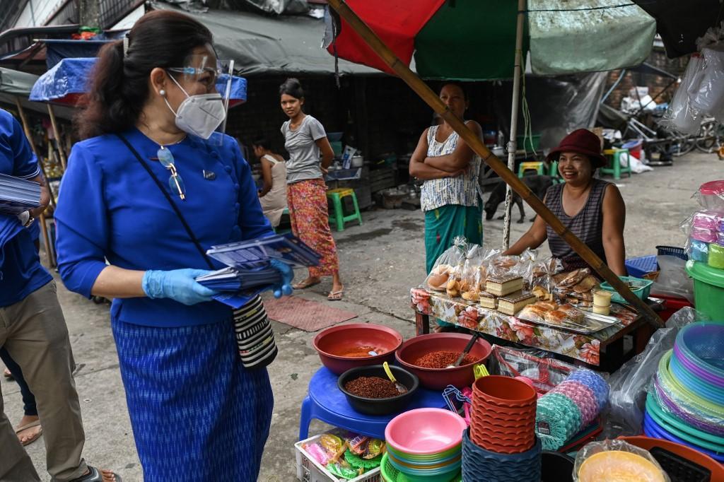 Thet Thet Khine (L), chairman of the People's Pioneer Party (PPP), give their campaign literature out to vendors during the launch of campaigning for the upcoming general election in Yangon on September 8, 2020. (Sai Aung Main / AFP)