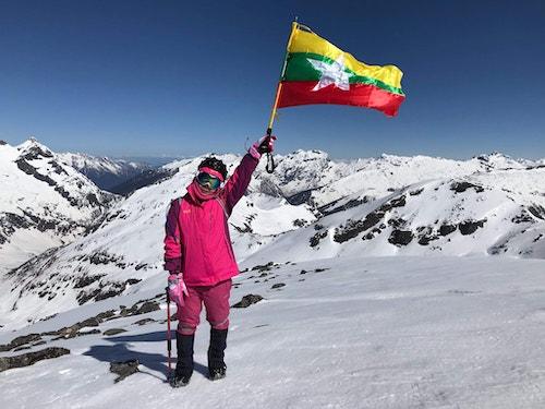 Saint Htet holds the Myanmar flag on Mount Phangran Razi. (The Summiter Group / Facebook)