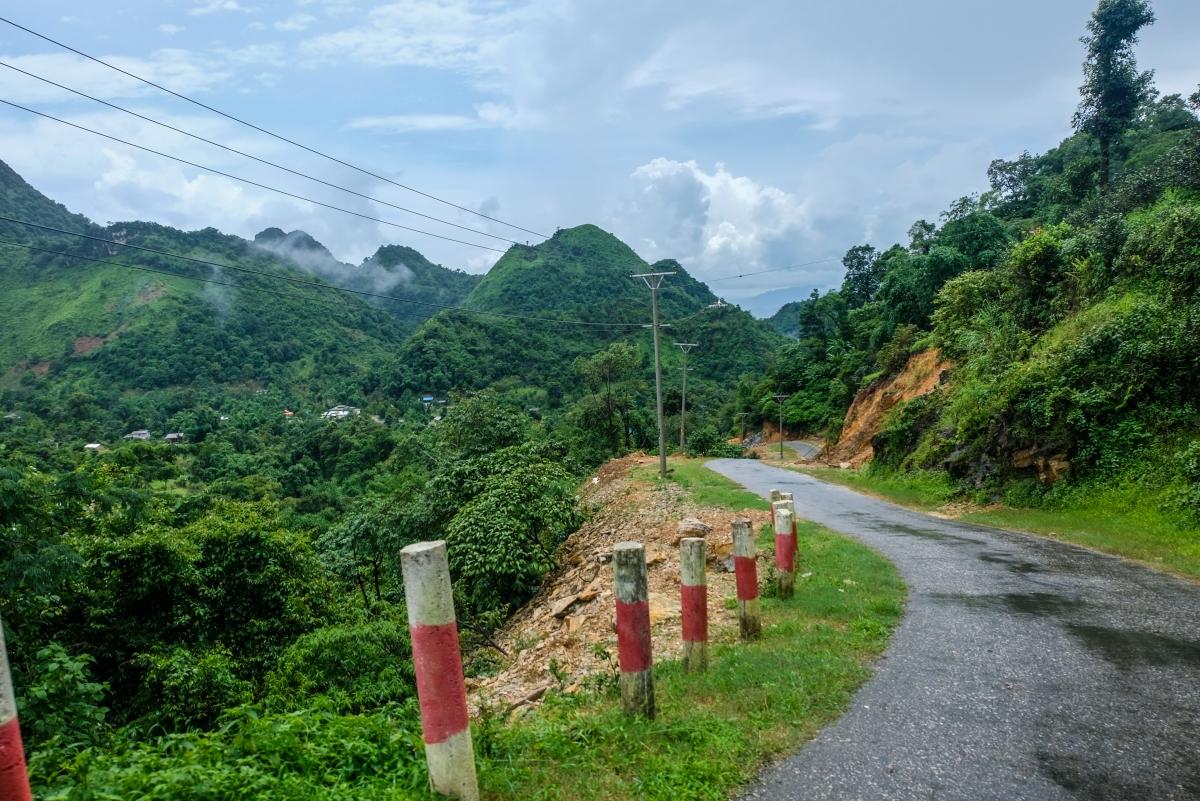 The narrow mountain road snakes between cloud-hugging peaks.