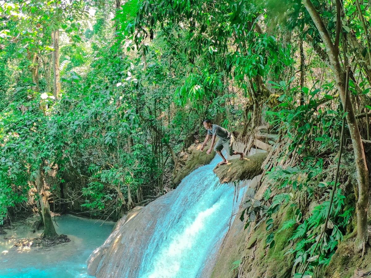 A visitor to Nant Mon Gyi falls leaps from a mossy perch into one of its glistening pools.