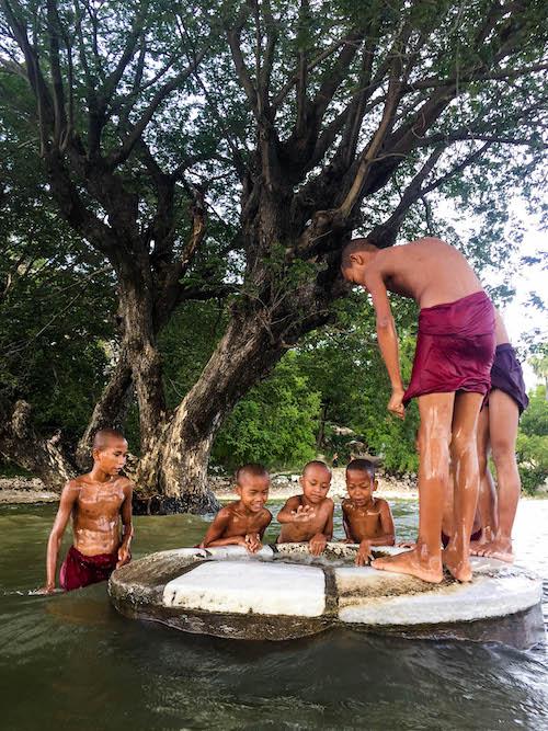 Boys look down a flooded well in Sakyin. (Adam Strand)