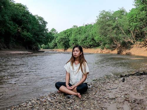 Meditating by the shallow river that marks the start to the lake. (Dominic Horner)